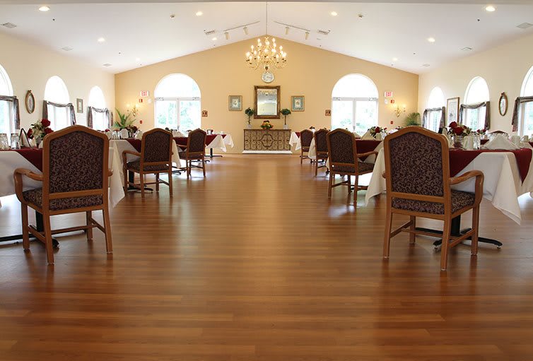 A spacious dining room with elegant furniture and a chandelier.