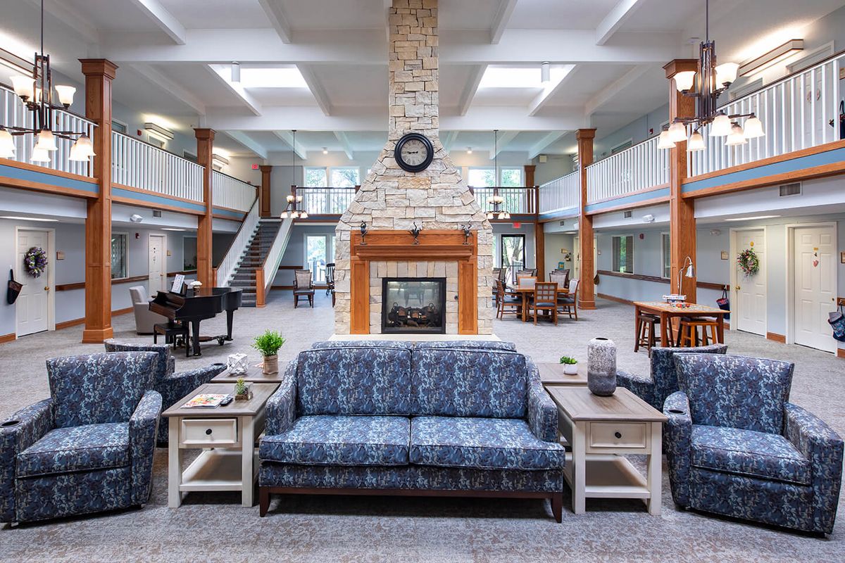 A spacious lobby with a central stone fireplace and comfortable seating.