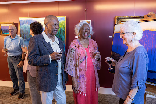 Guests engaging in conversation at an art gallery opening.