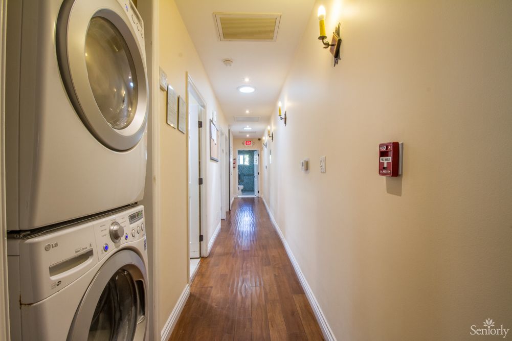 A bright hallway with a stacked washer and dryer on the left.