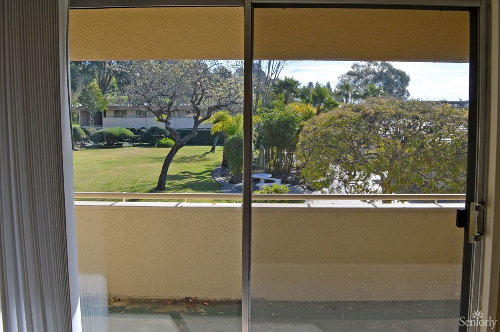 A scenic view from a balcony overlooking a lush garden on a sunny day.