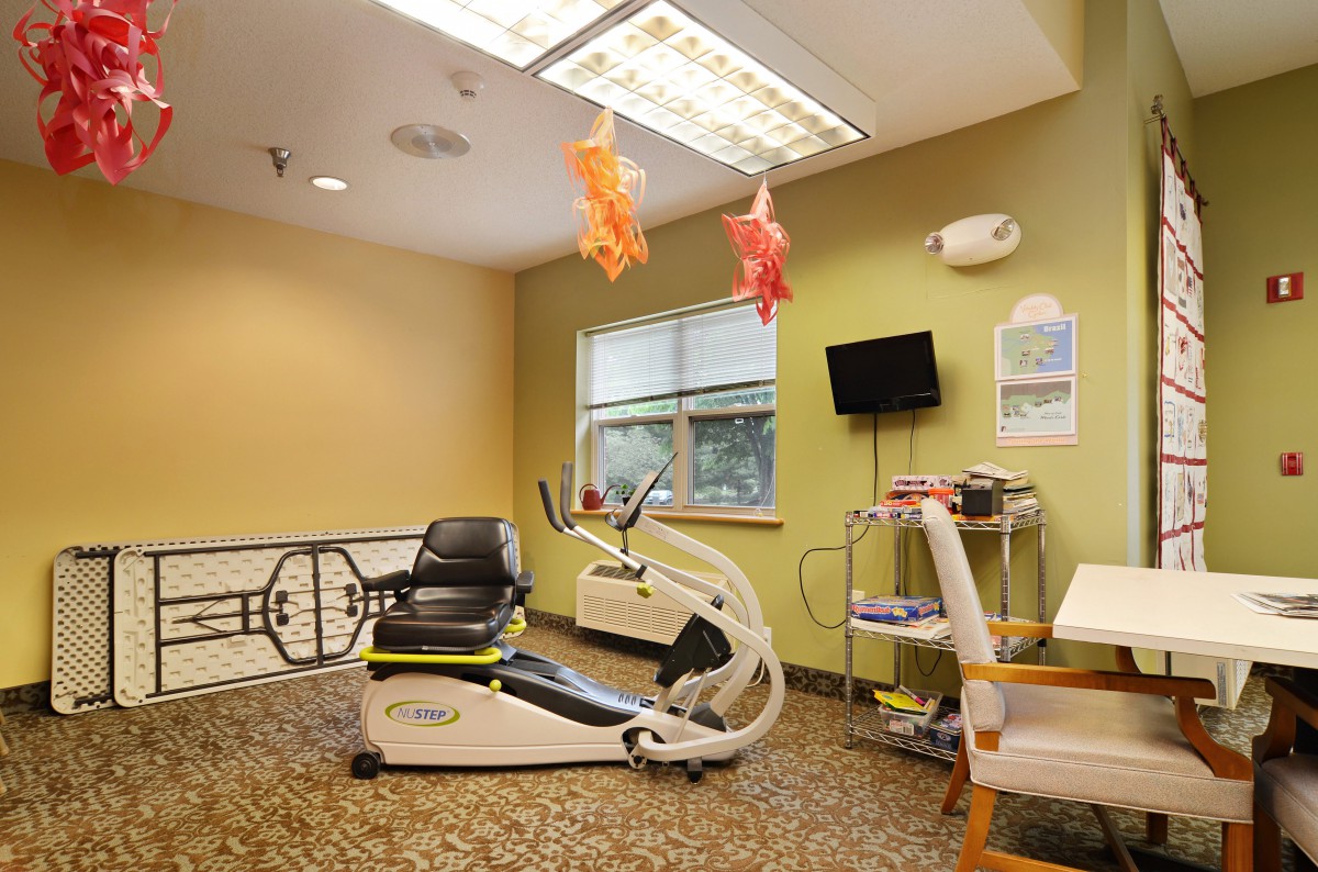A therapy room with a stationary bike and rehabilitation equipment.
