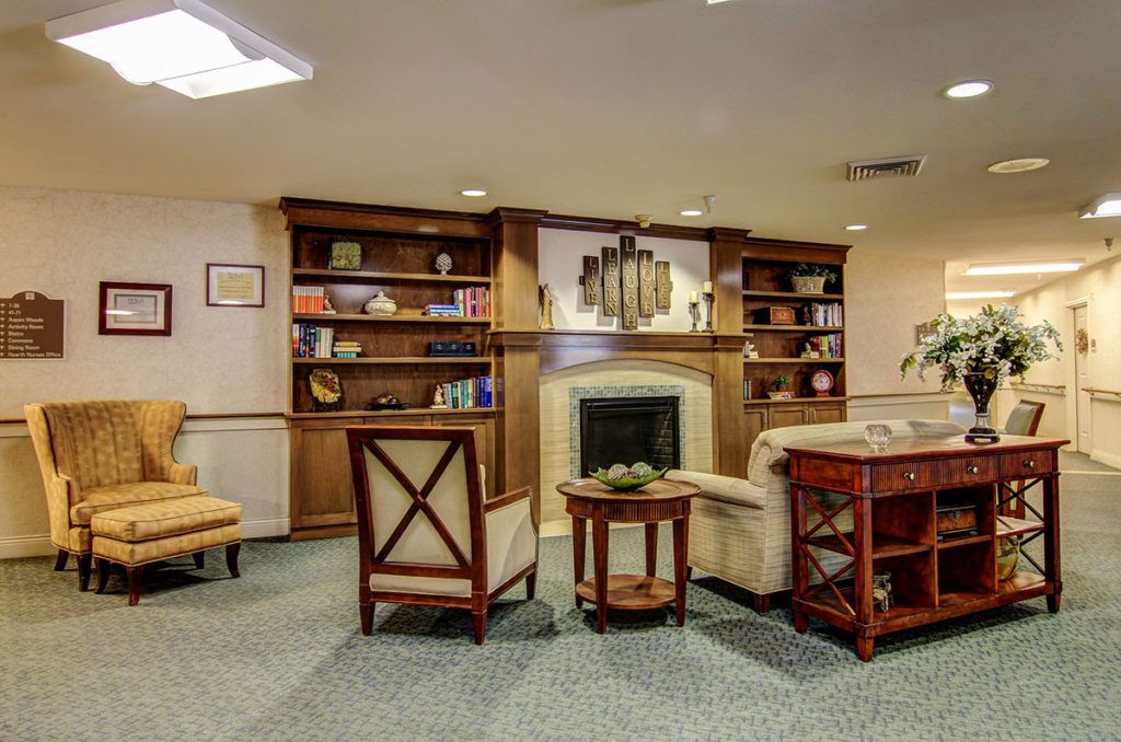 A cozy living room with a fireplace and built-in bookshelves.