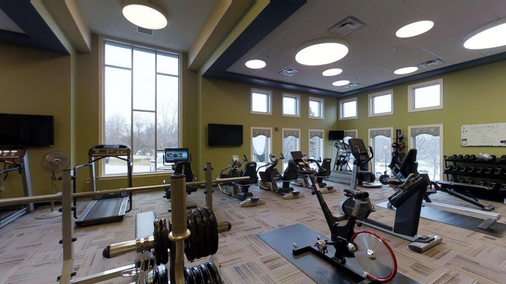 A modern gym with various exercise equipment and cardio machines.