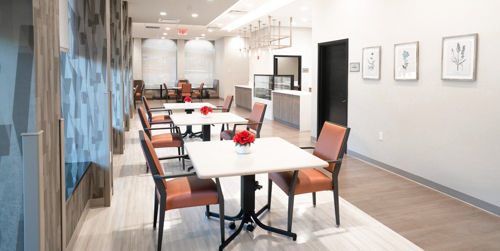 A modern and clean dining area with several tables and chairs, featuring minimalist decor.