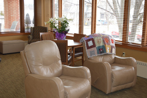A cozy living room featuring comfortable recliners, a wooden table, and fresh flowers.