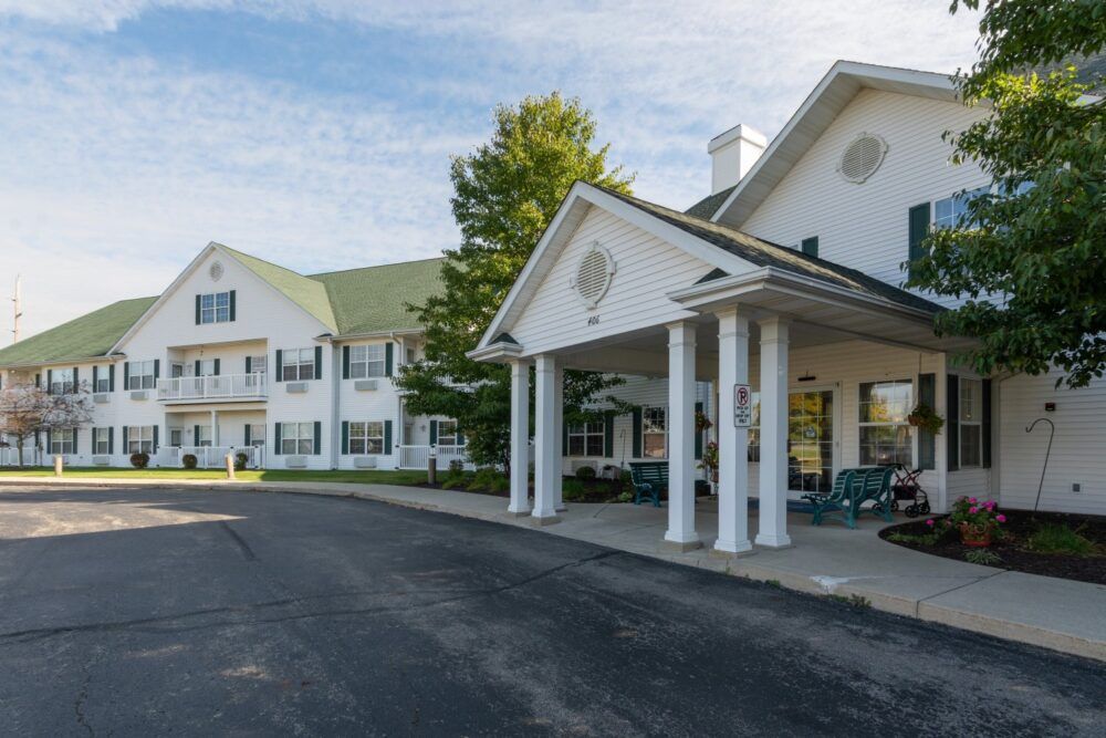 A large white building with a green roof and a welcoming entrance.