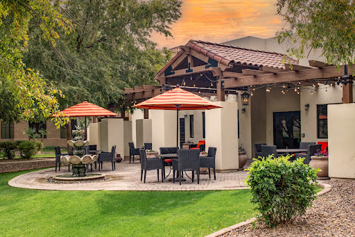 A serene outdoor dining area featuring comfortable seating and vibrant umbrellas, perfect for enjoying the sunset.