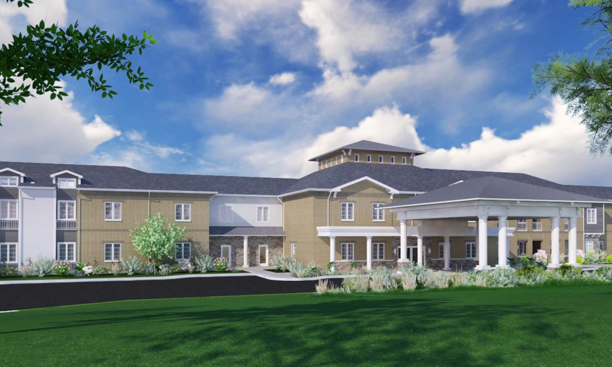 A modern two-story building with a landscaped lawn and cloudy sky backdrop.