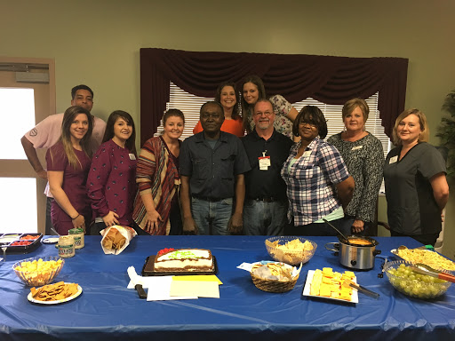 A cheerful group gathered for a celebration with food and dessert.