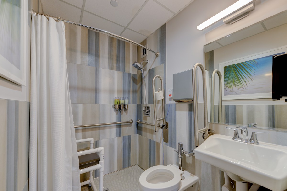 An accessible bathroom with modern features, including handrails for safety.