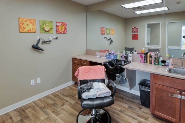 A cozy hair salon setup with styling chairs, mirrors, and colorful wall art.