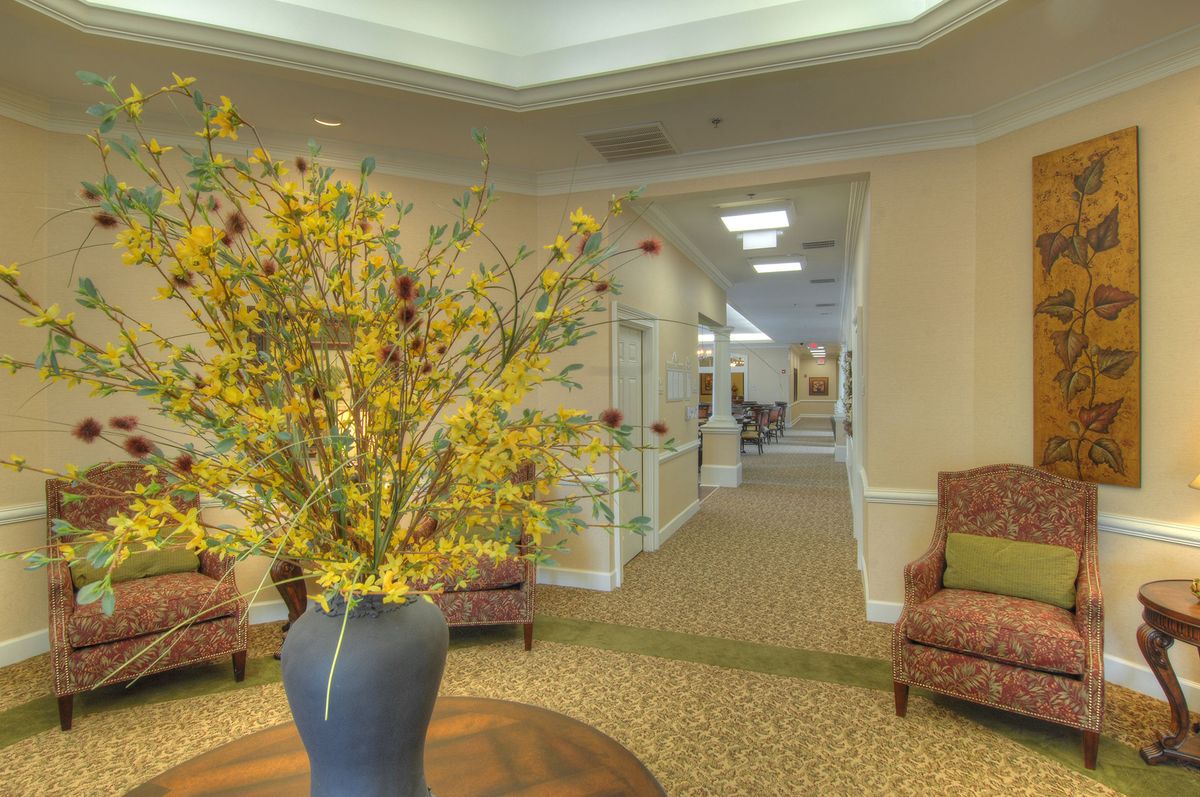 A welcoming lobby area with a large vase of flowers and comfortable seating.