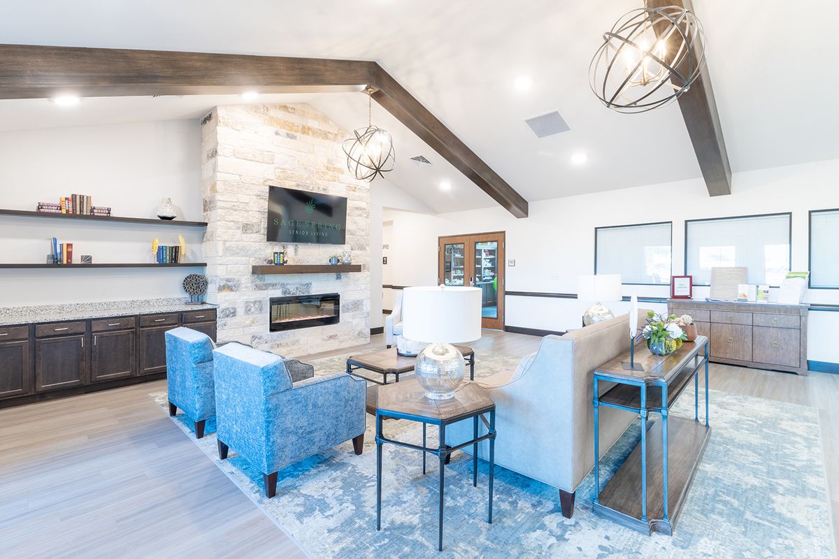 A modern living room featuring a stone fireplace, blue chairs, and contemporary decor.