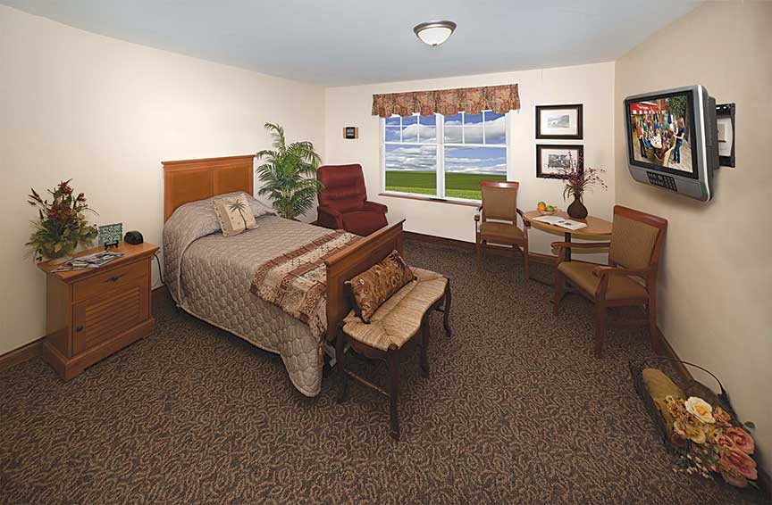 A well-furnished bedroom with a comfortable bed, chairs, and a window overlooking a scenic view.