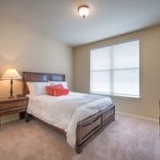 A minimalist bedroom with a bed, bedside table, and a lamp.