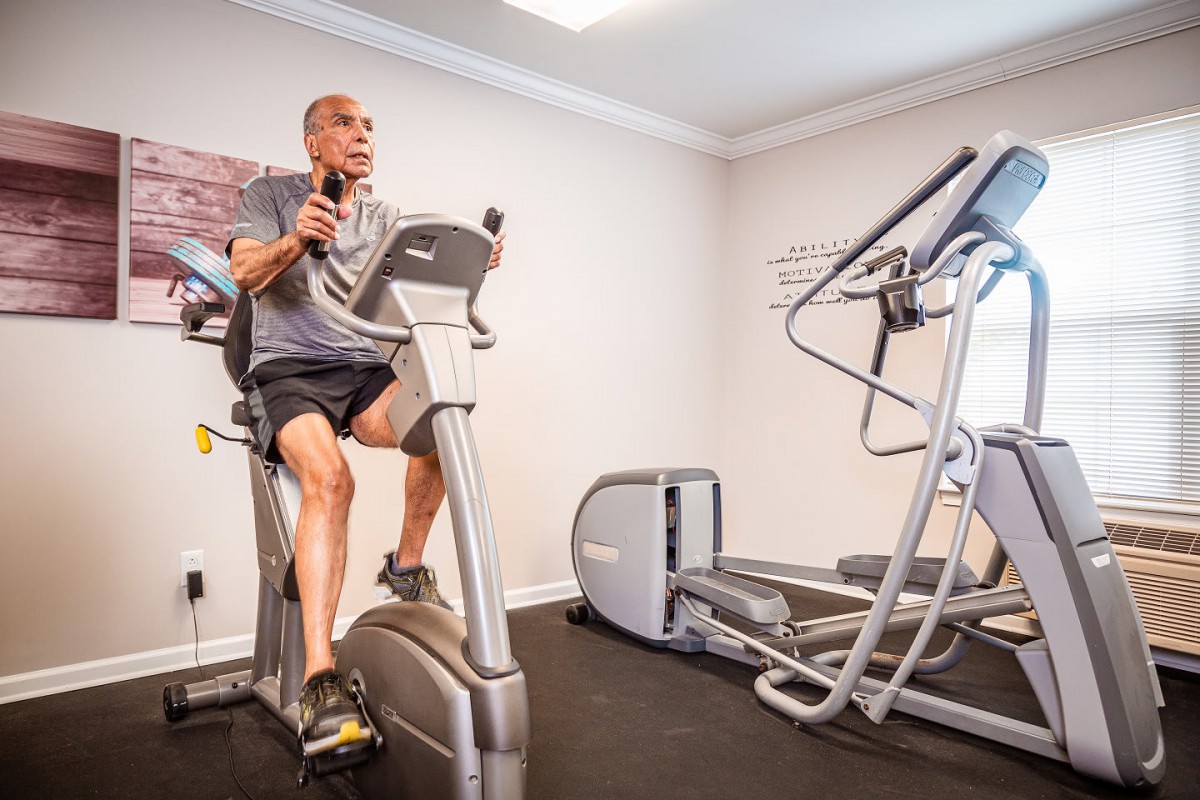 A person exercising on a stationary bike in a gym setting.
