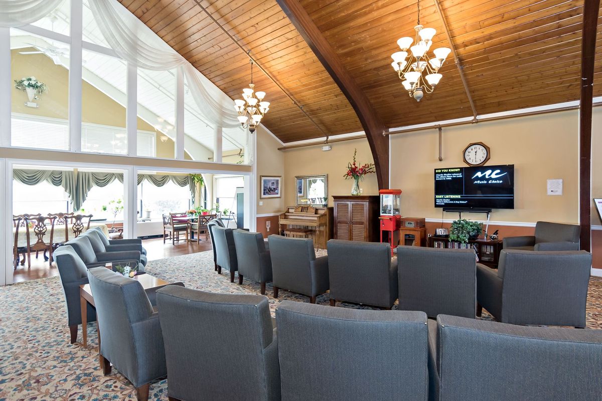 A spacious lobby with comfortable seating, a wooden ceiling, and large windows.