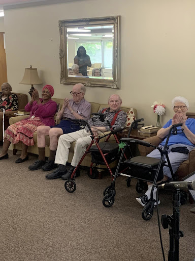 Seniors enjoying a joyful moment together at their care home.
