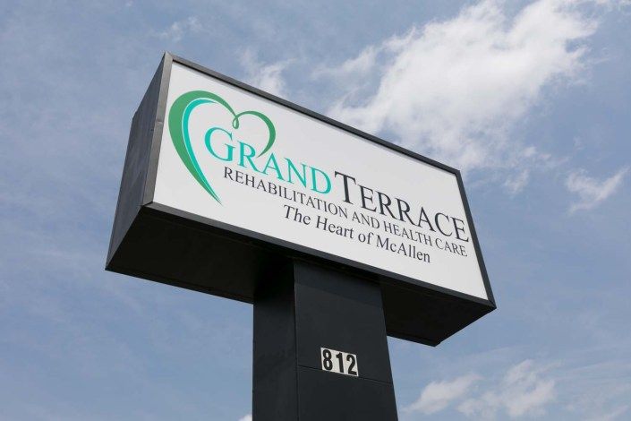 Sign for Grand Terrace Rehabilitation and Healthcare facility against a blue sky.