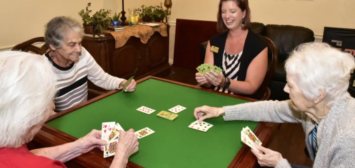 A group of people engaged in a card game at a table.