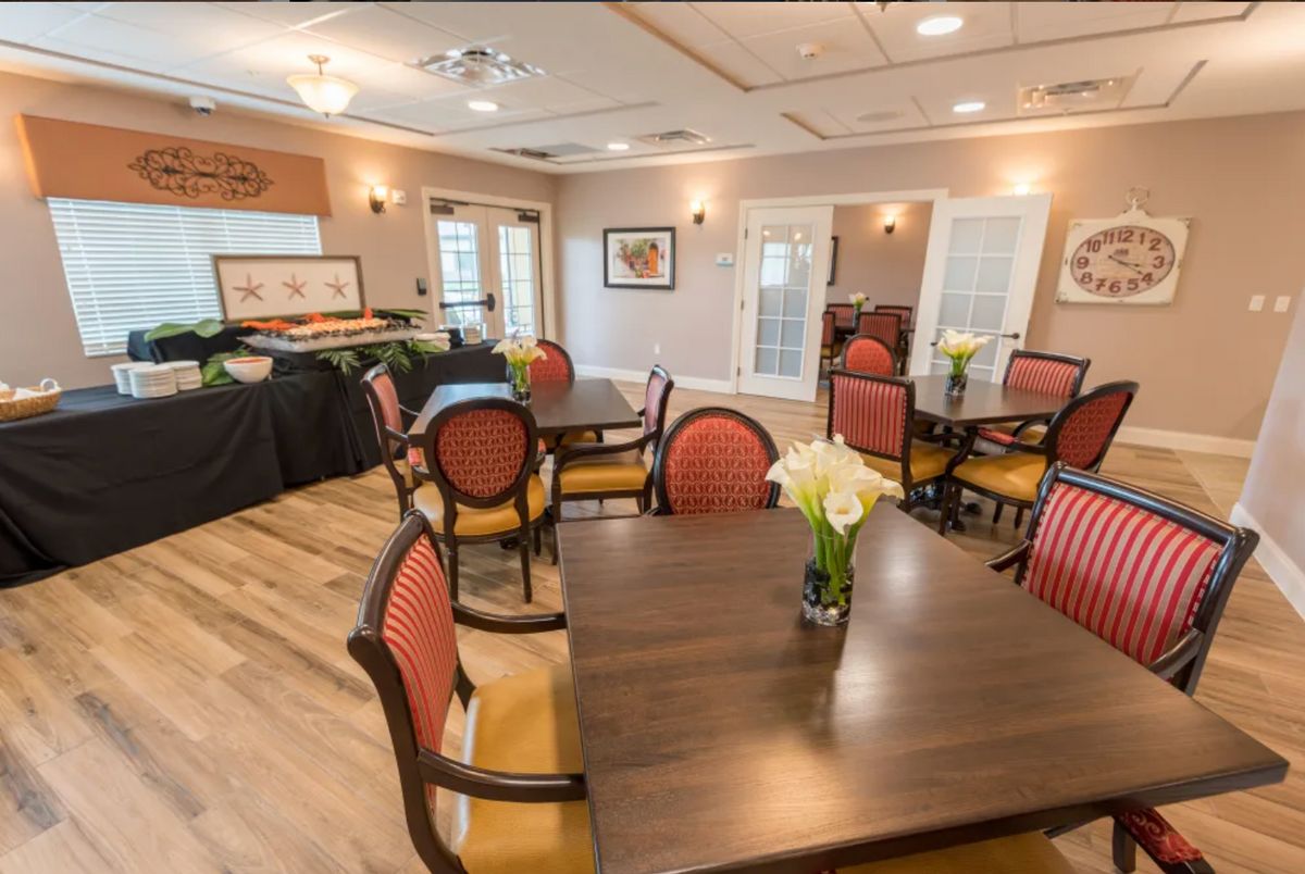 An elegant dining area with neatly arranged tables and chairs, adorned with floral centerpieces.