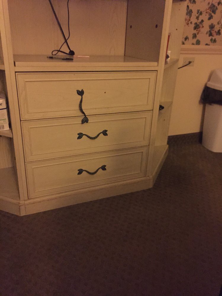 A set of drawers with decorative handles in a room.