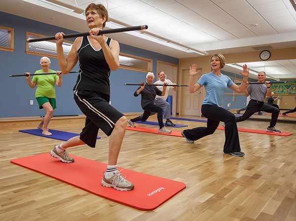 A group of seniors participating in an exercise class using fitness bars.