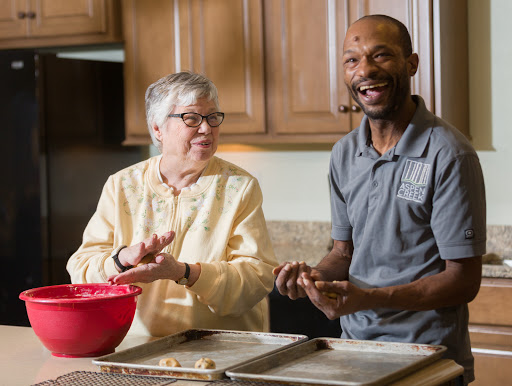 A joyful moment in the kitchen as two friends enjoy baking together.