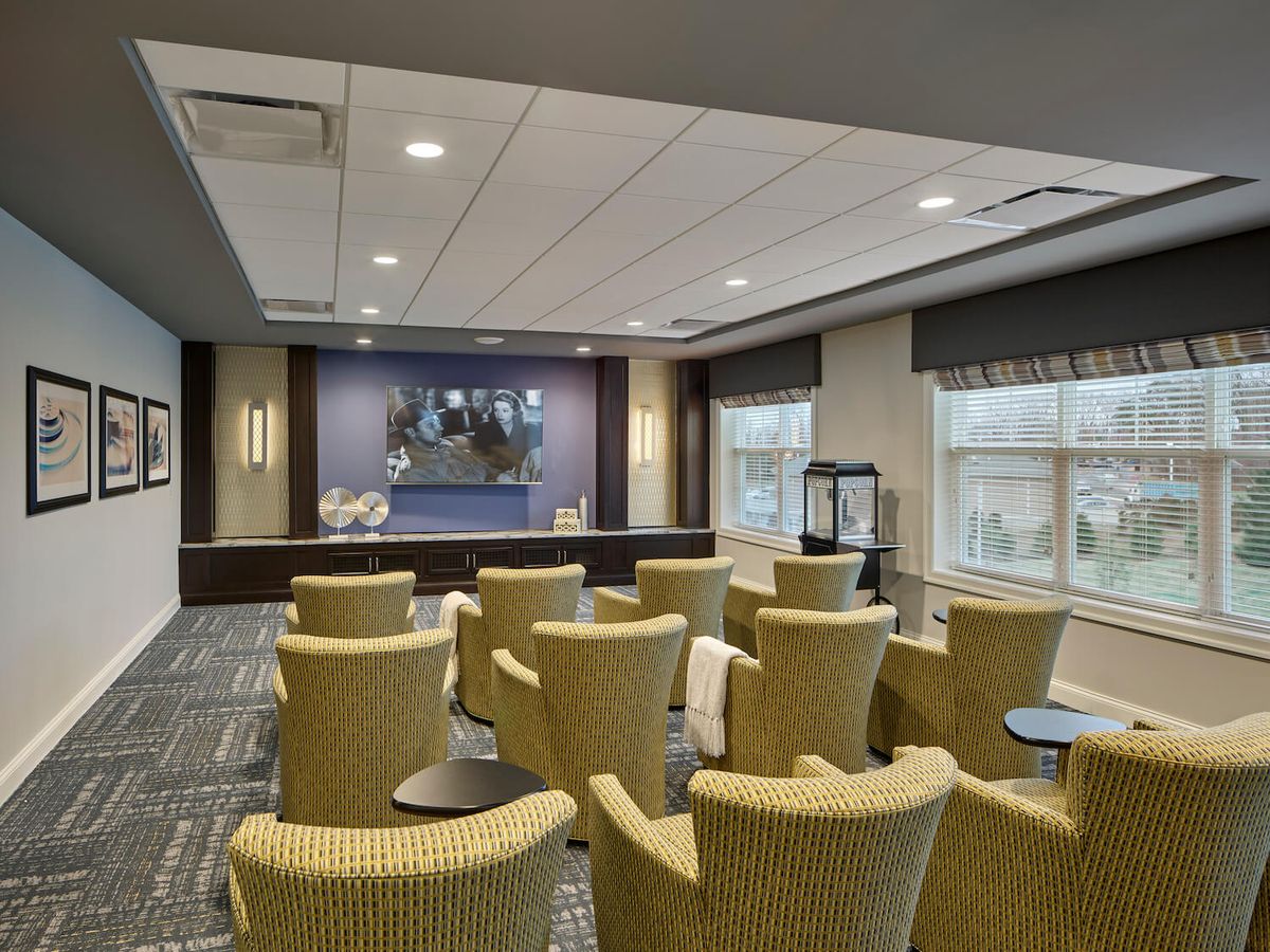 A modern conference room with arranged seating and a projector screen.