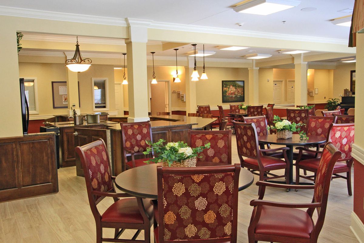 A well-lit and elegantly furnished dining area with multiple tables and chairs.