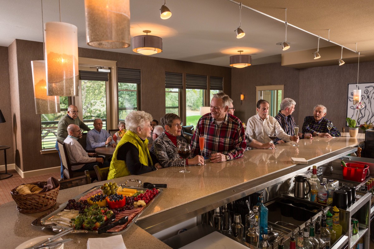 A group of people sitting at a bar, enjoying a social gathering indoors.