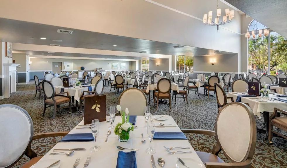 An elegant dining room set up with neatly arranged tables and chairs.