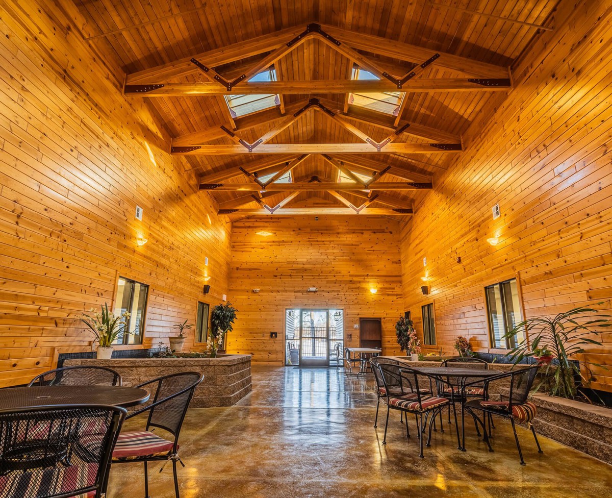 A spacious wooden lodge interior with high ceilings and seating area.