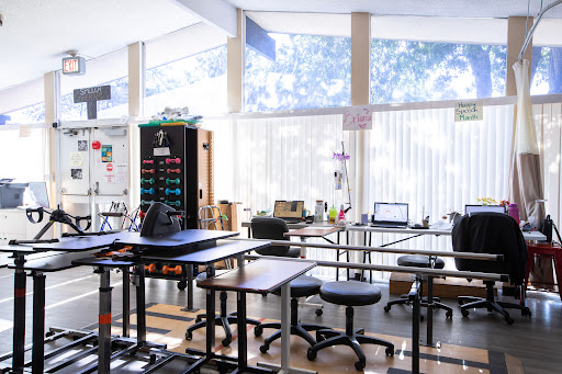A spacious and well-lit classroom filled with modern furniture, including tables and chairs, providing an ideal workspace for learning.