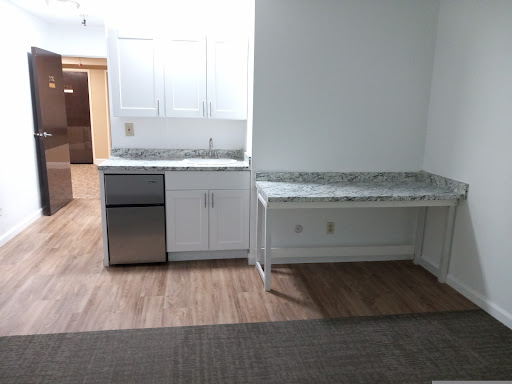 A modern kitchen space featuring a stainless steel sink, countertop, and minimalistic design.