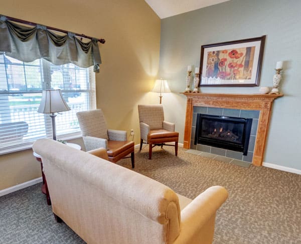 A cozy living room with a sofa, chairs, and a fireplace.