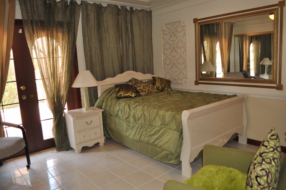 A cozy bedroom with a green theme and classic furnishings.