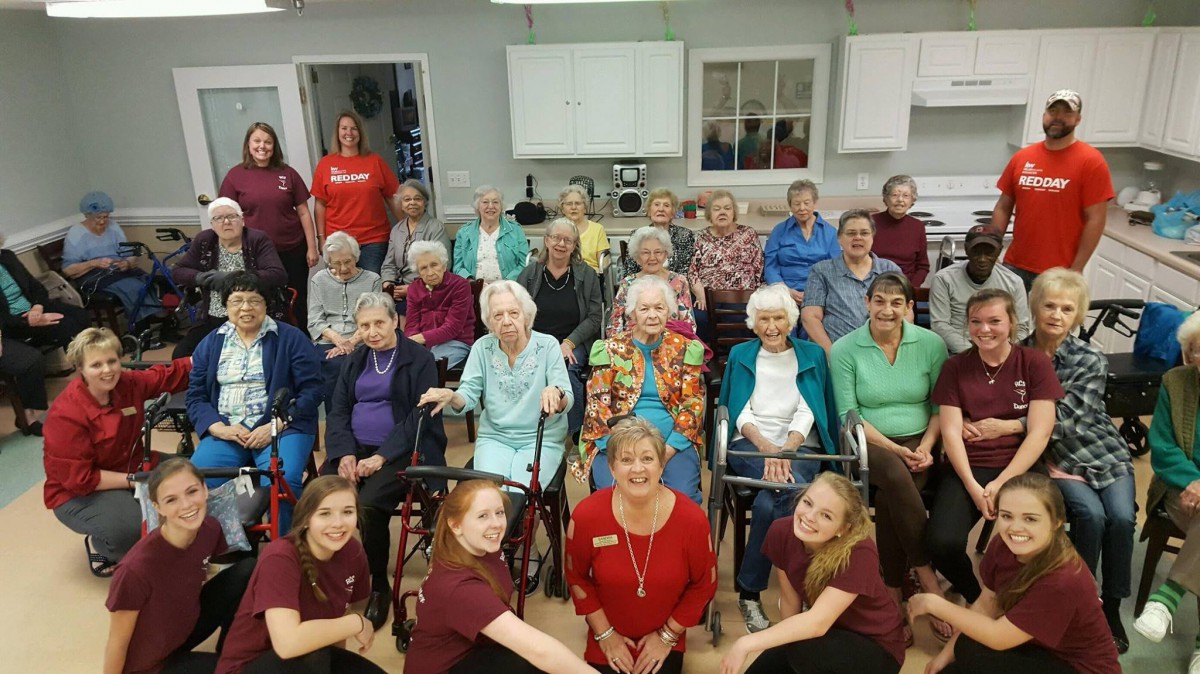 A group photo of seniors and staff at a care facility.