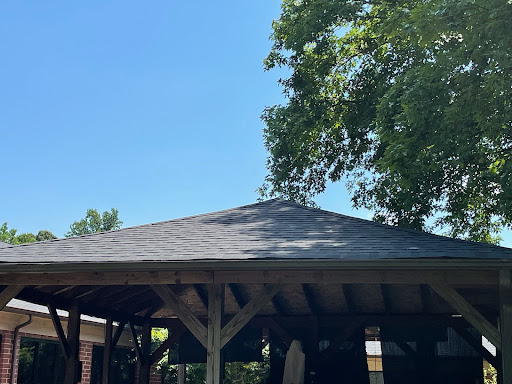 A beautiful gazebo under a clear blue sky, surrounded by lush greenery.