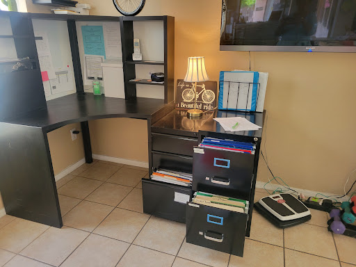 A well-organized home office setup featuring a desk, filing cabinets, and a lamp.
