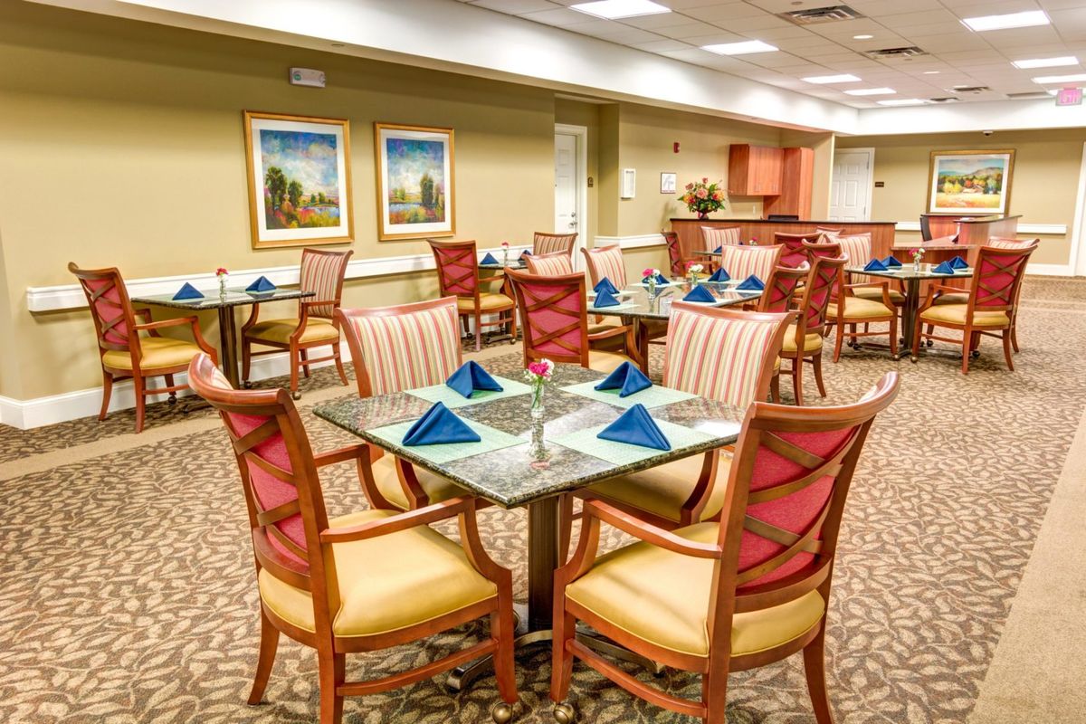 Elegantly set dining area with tables and chairs.
