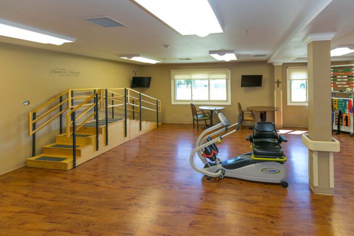 A rehabilitation room equipped with exercise machines and therapy apparatuses.