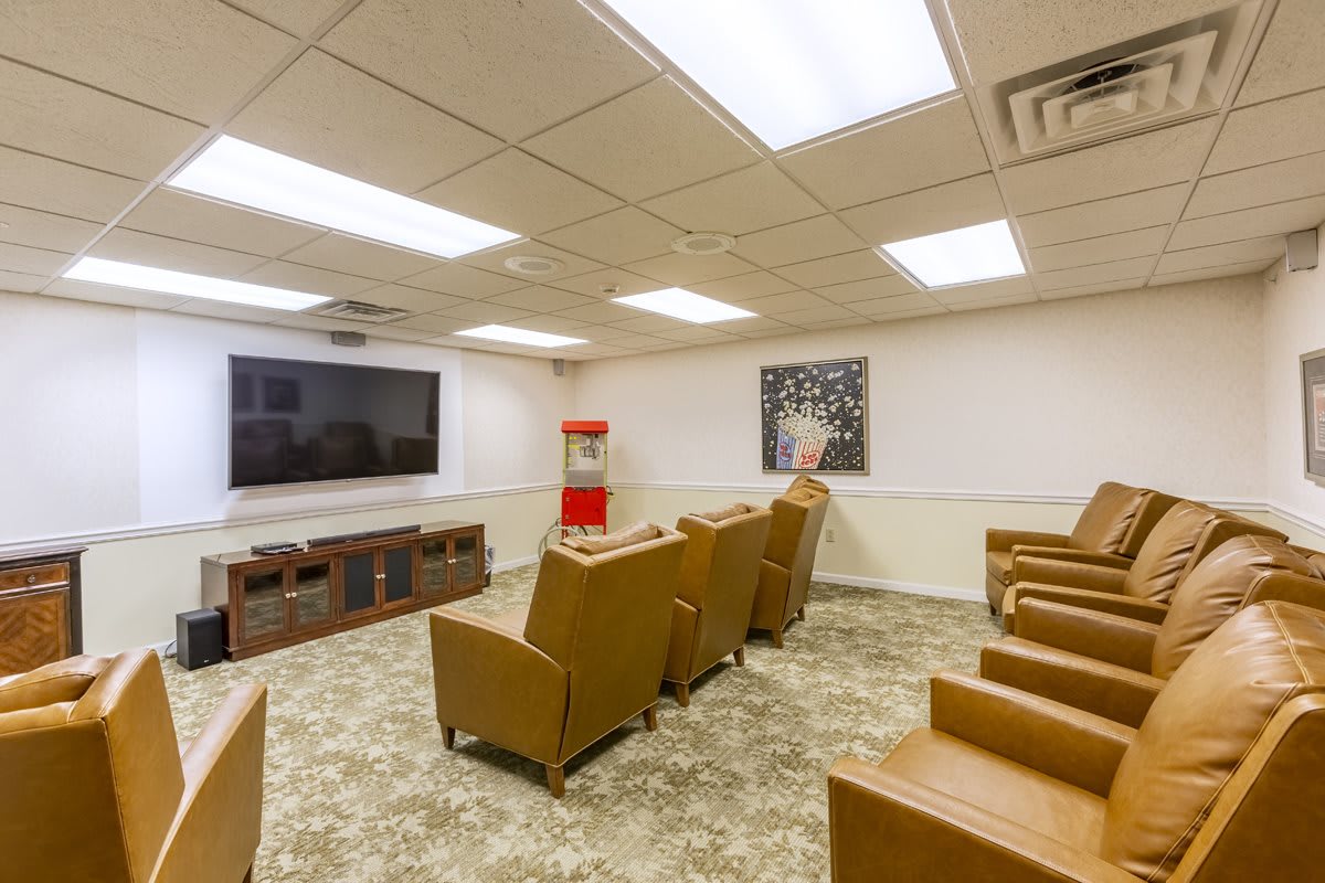 A modern home theater with comfortable seating, a large screen, and a popcorn machine.