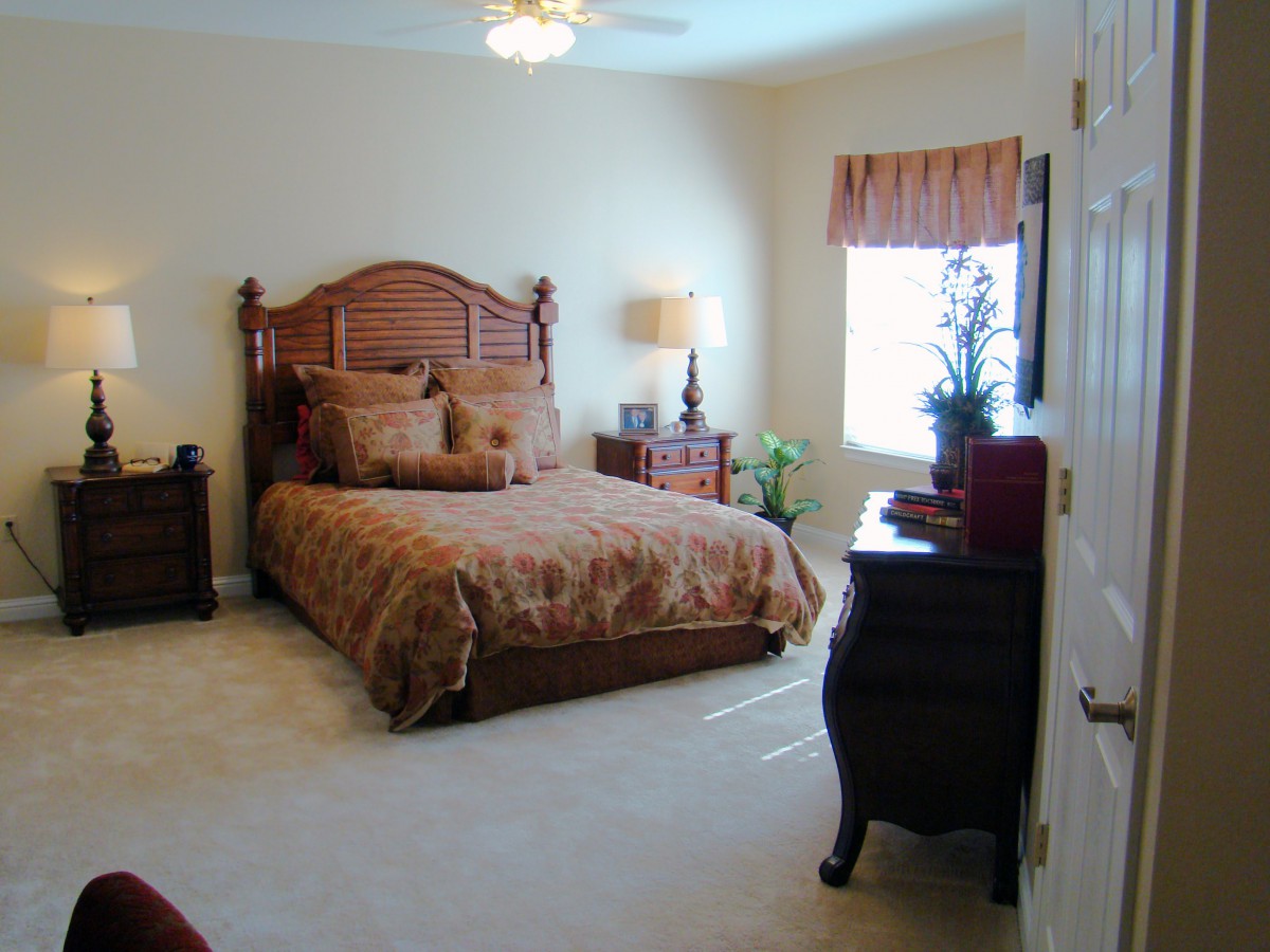 A well-decorated bedroom with a wooden bed and matching furniture.