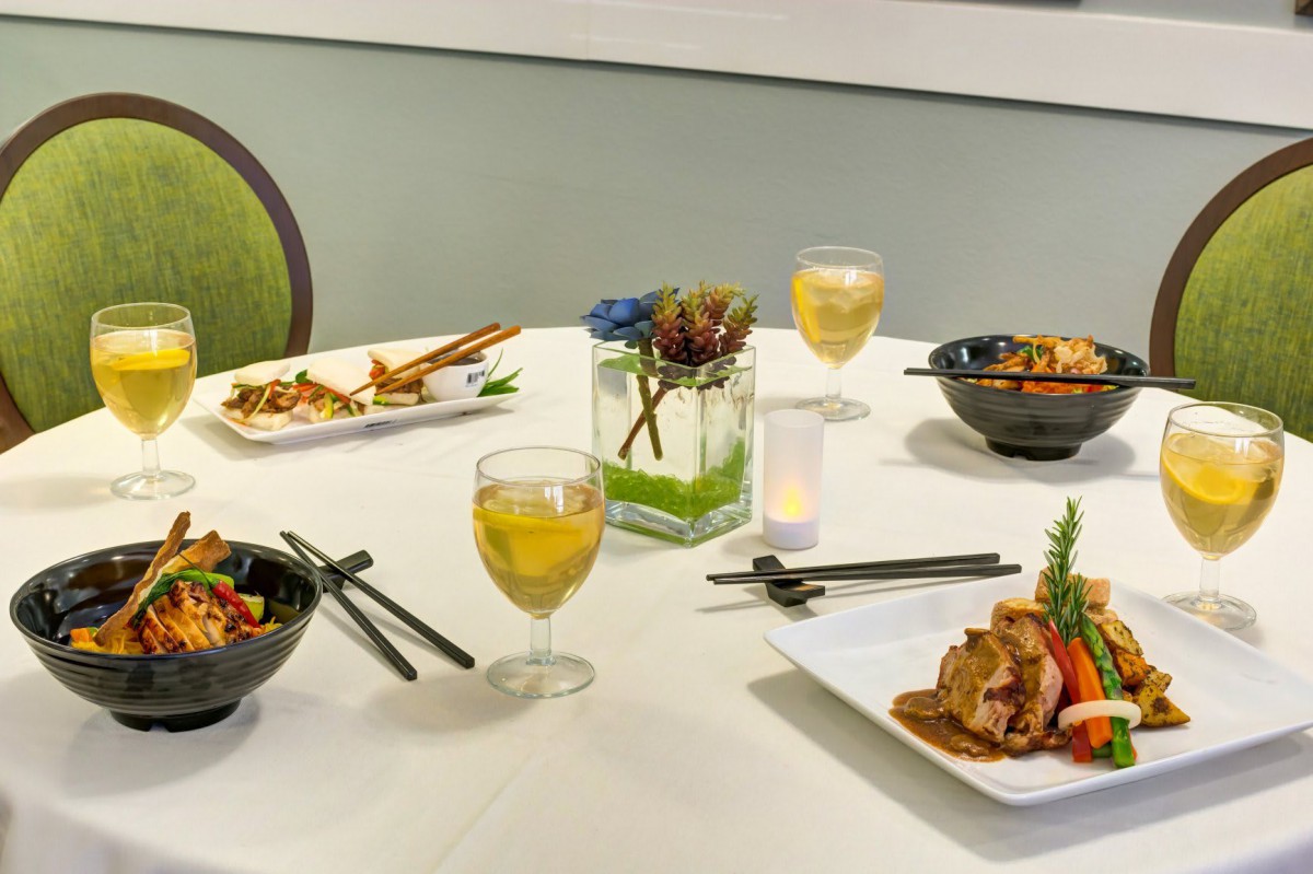 A beautifully set dining table with a variety of dishes and drinks.