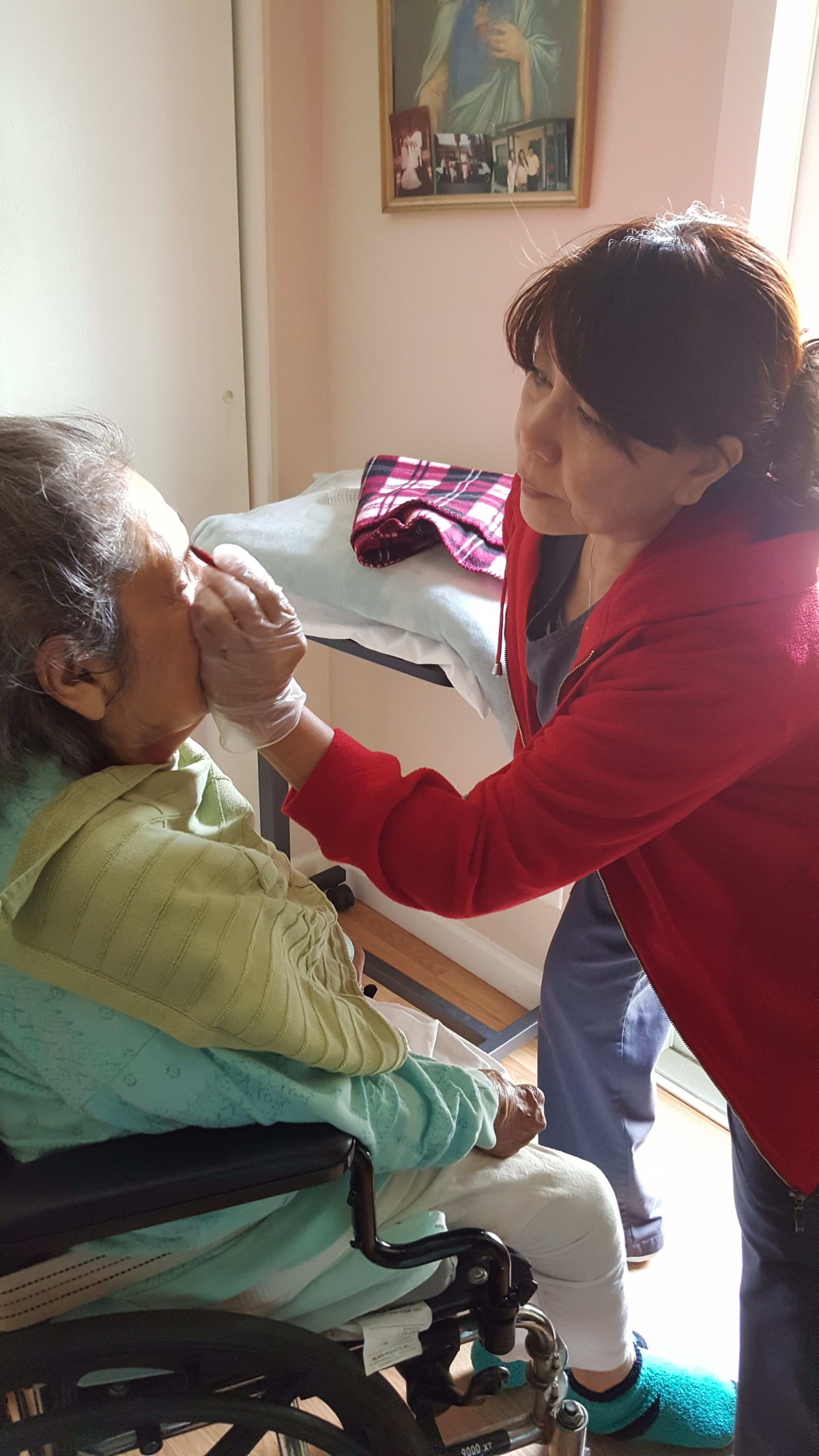 A caregiver assists an elderly person with their needs in a home setting.
