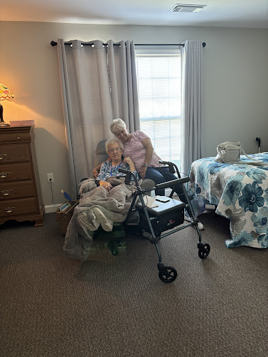 A heartwarming moment of companionship between two elderly individuals in a cozy room.
