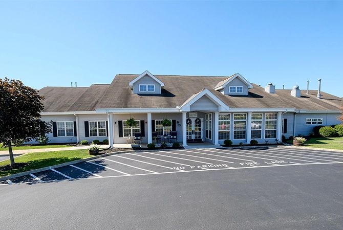 A commercial building with a spacious parking lot under a clear blue sky.
