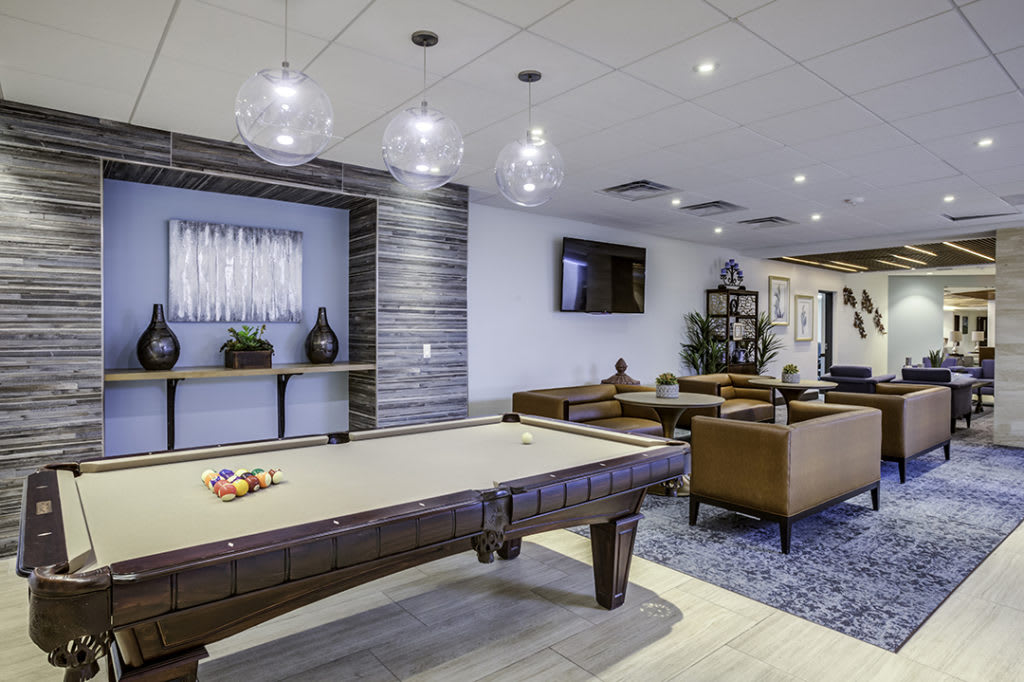 A modern game room featuring a pool table, comfortable seating, and stylish decor.